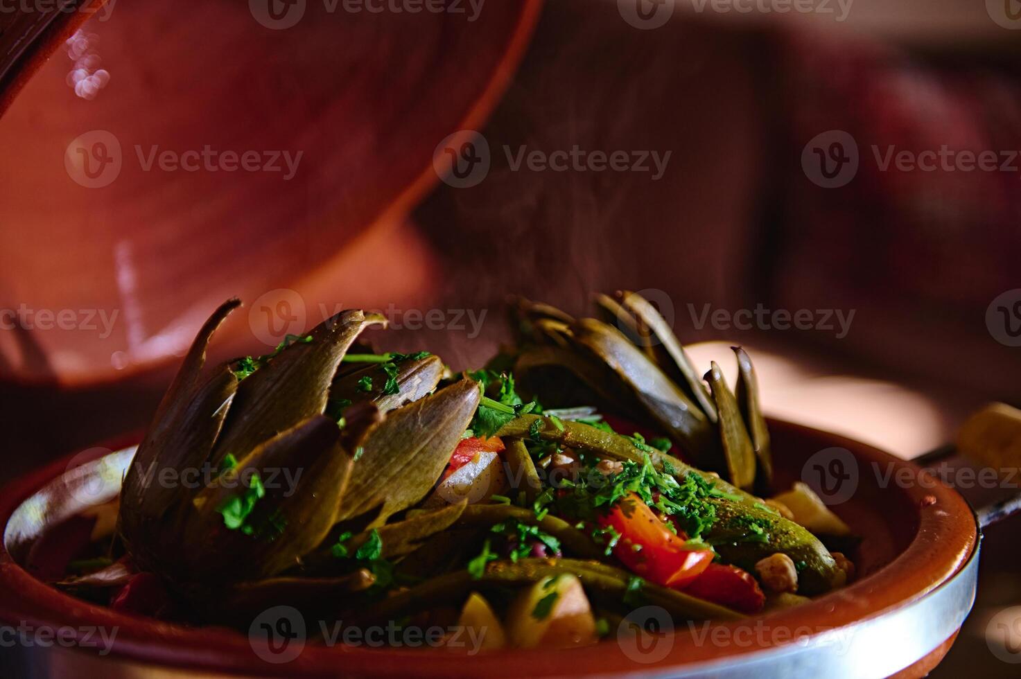 Nahansicht Artischocke und Gemüse gedämpft im Lehm Gericht - - marokkanisch Tajine und gewürzt mit frisch gehackt Petersilie foto