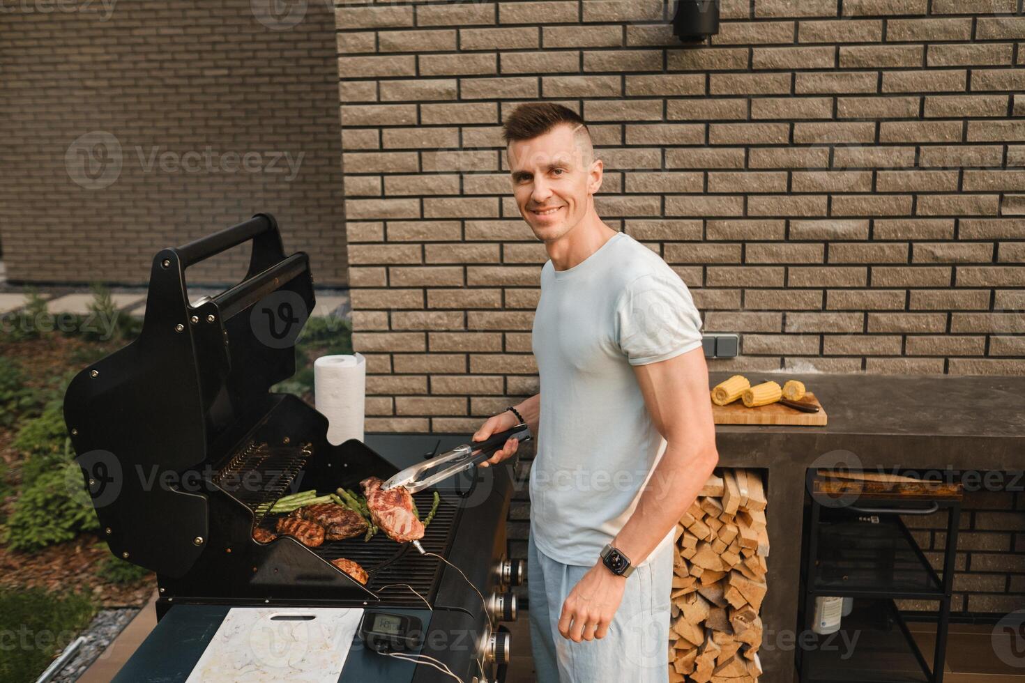 ein Mann auf das Straße ist Kochen ein Steak auf das Grill beim ein Grill foto