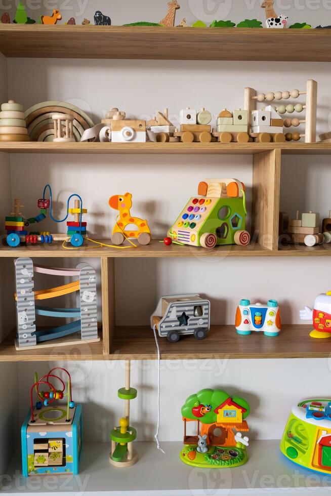 ein Regal mit Kinder- hölzern Spielzeuge im das Kinder- Zimmer. Kinder- Konzept foto