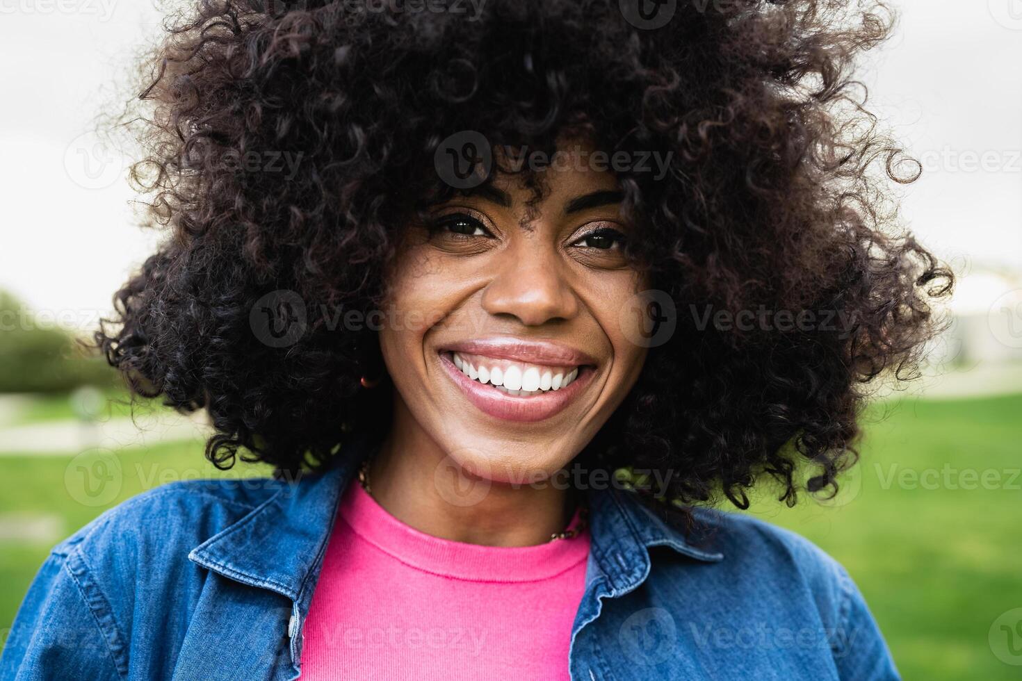 glücklich afrikanisch amerikanisch Frau haben Spaß suchen im Vorderseite von ein Kamera im Öffentlichkeit Park foto