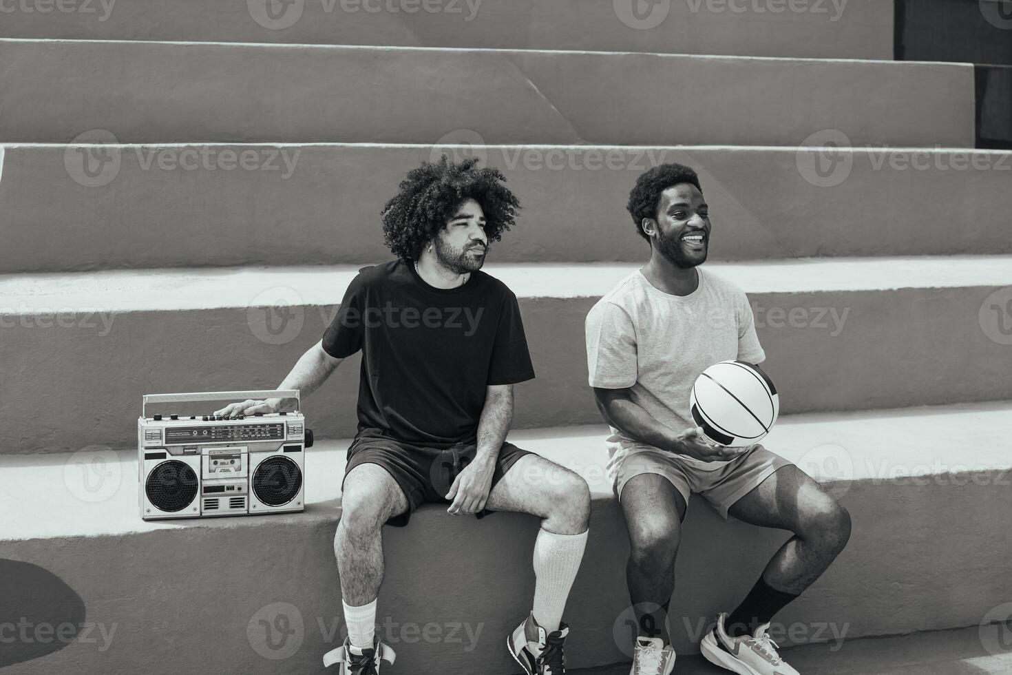 glücklich afrikanisch amerikanisch Männer Hören Musik- Innerhalb Basketball Gericht mit Jahrgang Boombox Stereo - - städtisch Straße Menschen Lebensstil - - schwarz und Weiß Bearbeitung foto