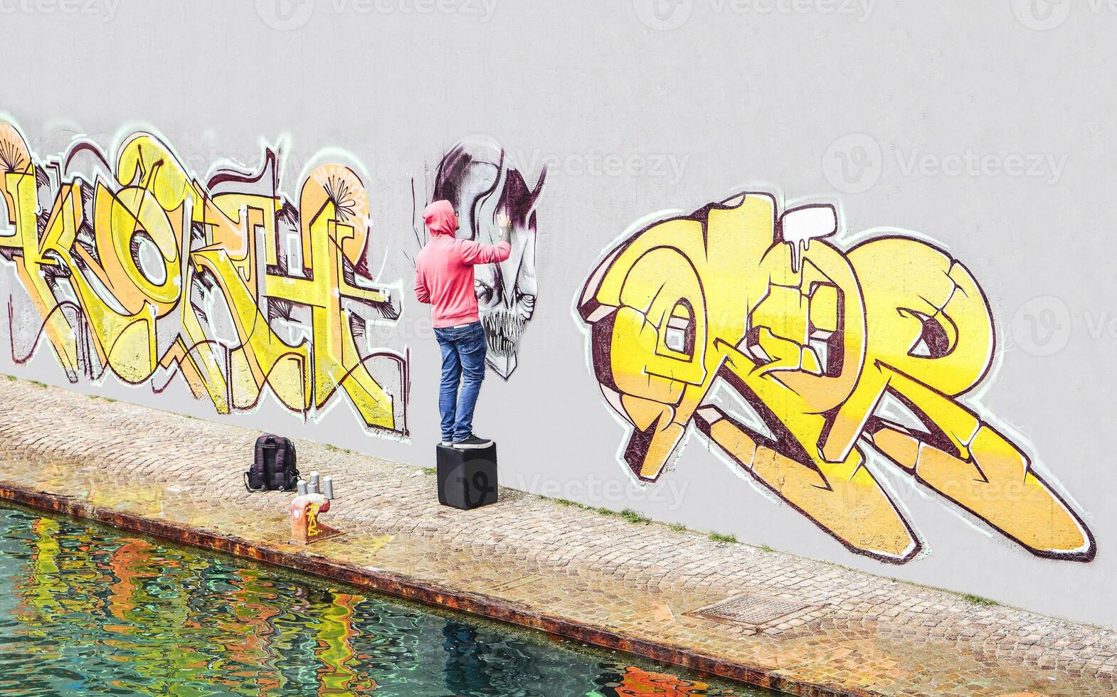 Straße Graffiti Künstler Gemälde mit ein Farbe sprühen können ein Graffiti auf das Mauer im das Stadt - - Konzept von zeitgenössisch Kunst Lebensstil foto