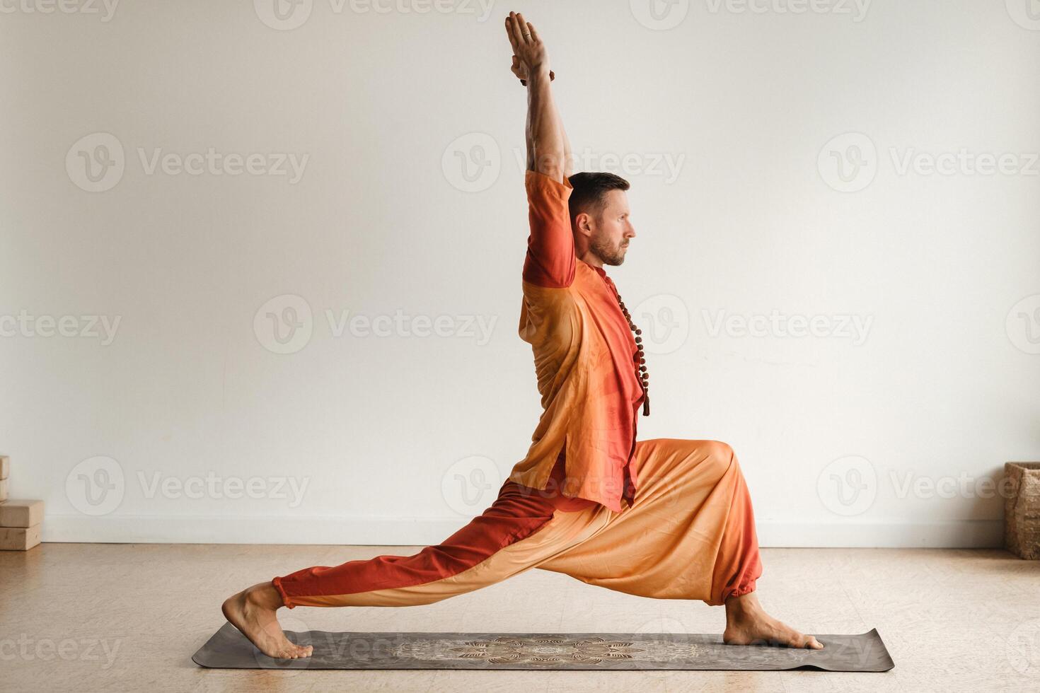 ein Mann im ein Orange passen tut Yoga im ein Fitness Zimmer. das Konzept von Gesundheit foto
