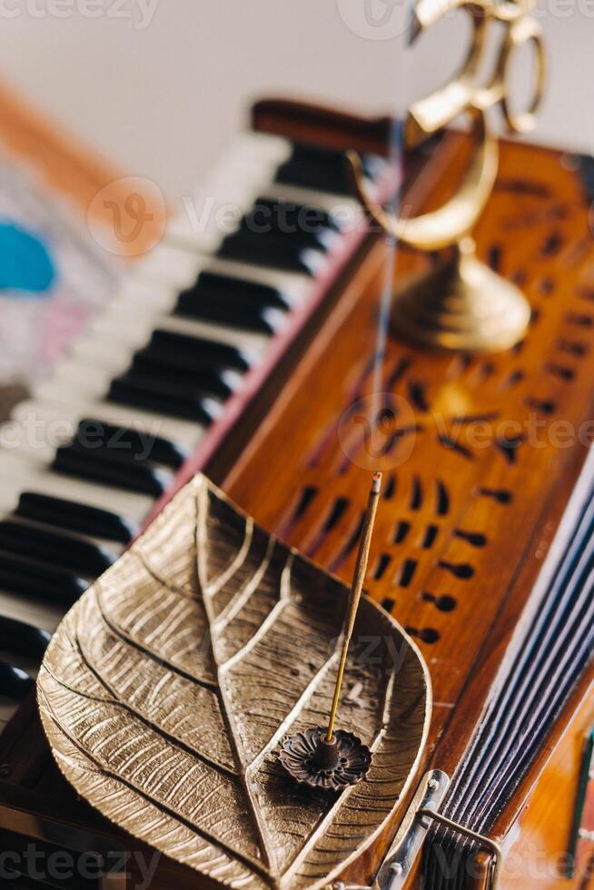 Harmonium während das trainieren von Kundalini Yoga und das Weihrauch Stehen auf es foto