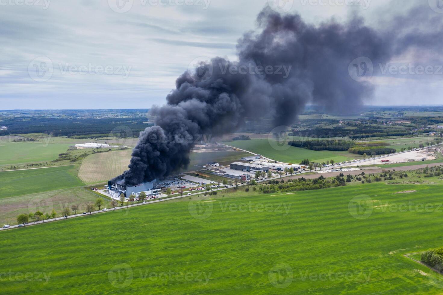 Antenne Aussicht von verbrannt industriell Warenhaus oder Logistik Center Gebäude nach groß Feuer mit enorm Rauch von verbrannt Dach foto