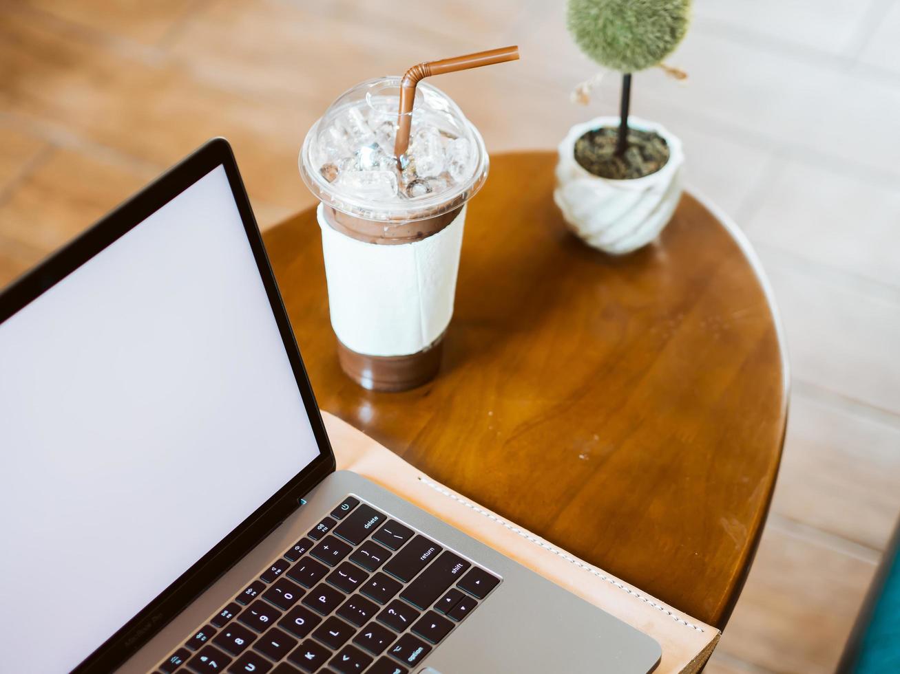 weißer leerer Display-Laptop auf dem Tisch im Kaffee-Café. foto