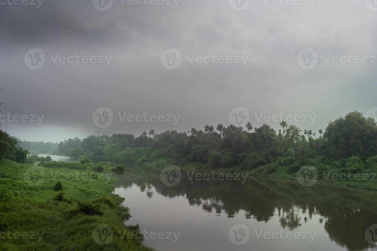 ein Landschaft Aussicht von ein Ruhe Fluss mit Grün Bäume und Berg im Indien foto