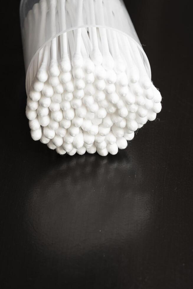 Makro Aussicht von Weiß Baumwolle Ohr Reinigung Knospen vereinbart worden im schwarz Hintergrund schön im ein Container foto