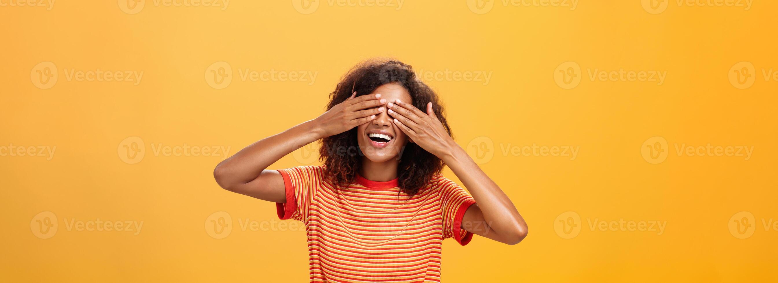 Schließen meine Augen und Zählen zehn. Porträt von charmant verträumt und glücklich komisch afrikanisch amerikanisch lockiges Haar weiblich im gestreift modisch T-Shirt Abdeckung Sicht mit Palme und lächelnd warten Überraschung foto