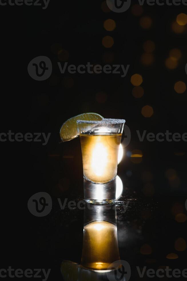 Mexikaner Gold Tequila mit Limette und Salz- auf schwarz Hintergrund mit Exemplar. foto