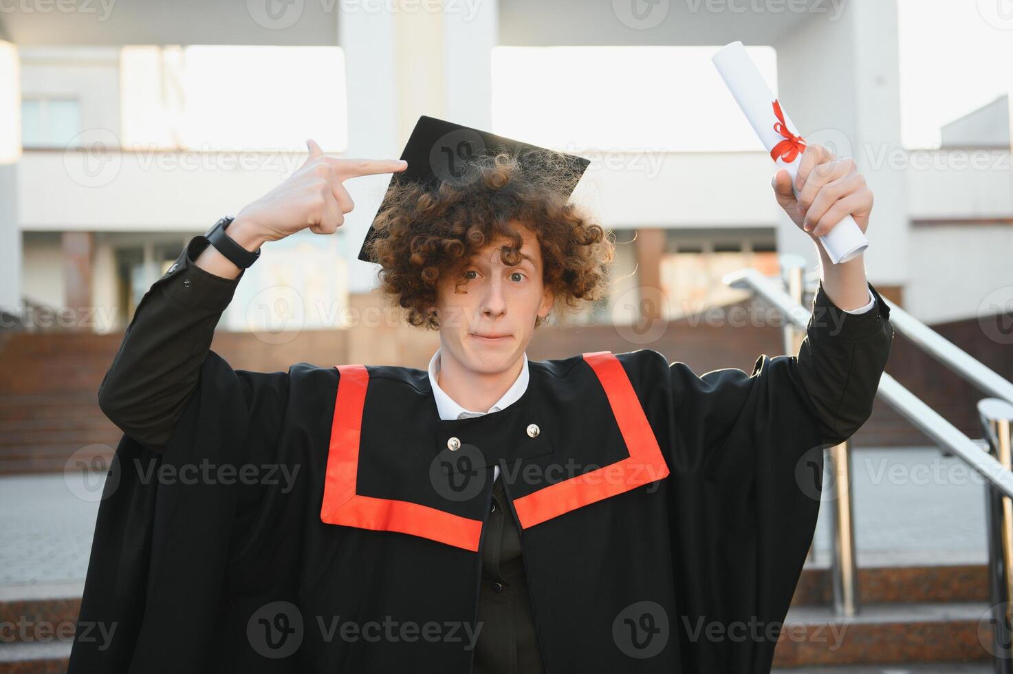 glücklich lächelnd Universität Absolvent im Mantel halten Diplom im angehoben Hand und ausdrücken Glück Über Universität Gebäude beim Hintergrund. erfolgreich Abschluss von Universität oder Hochschule foto