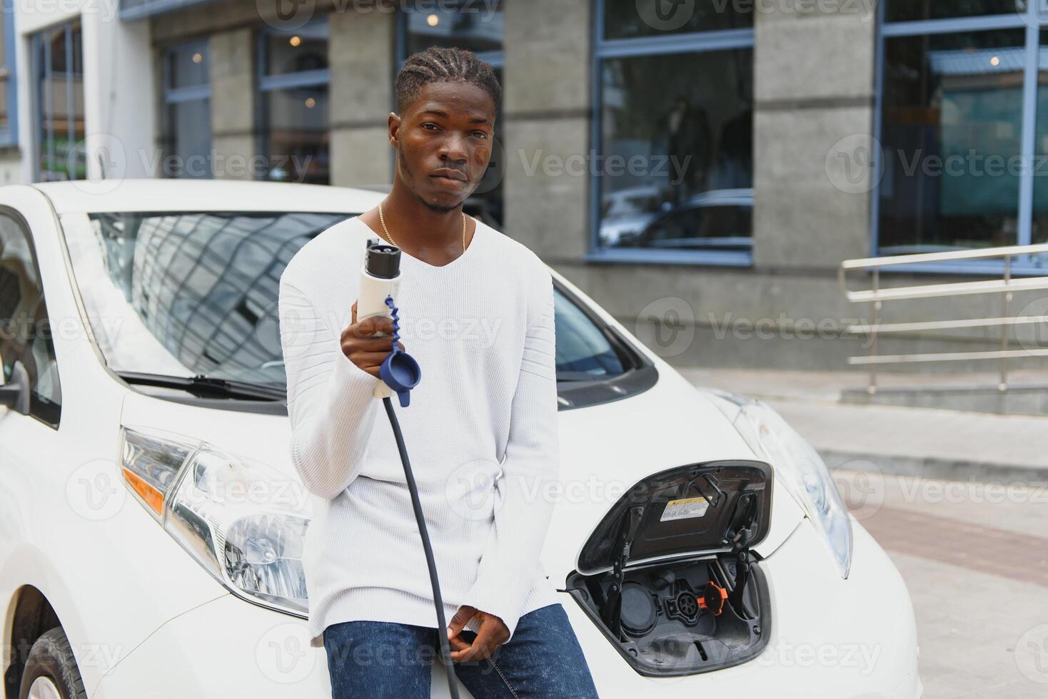 afrikanisch amerikanisch Mann Laden seine elektrisch Wagen. foto