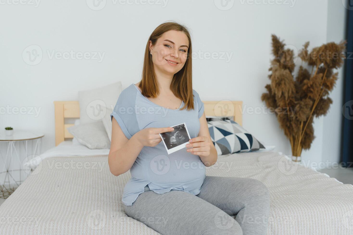 schwanger Frau halten Ultraschall Scan auf ihr Bauch foto