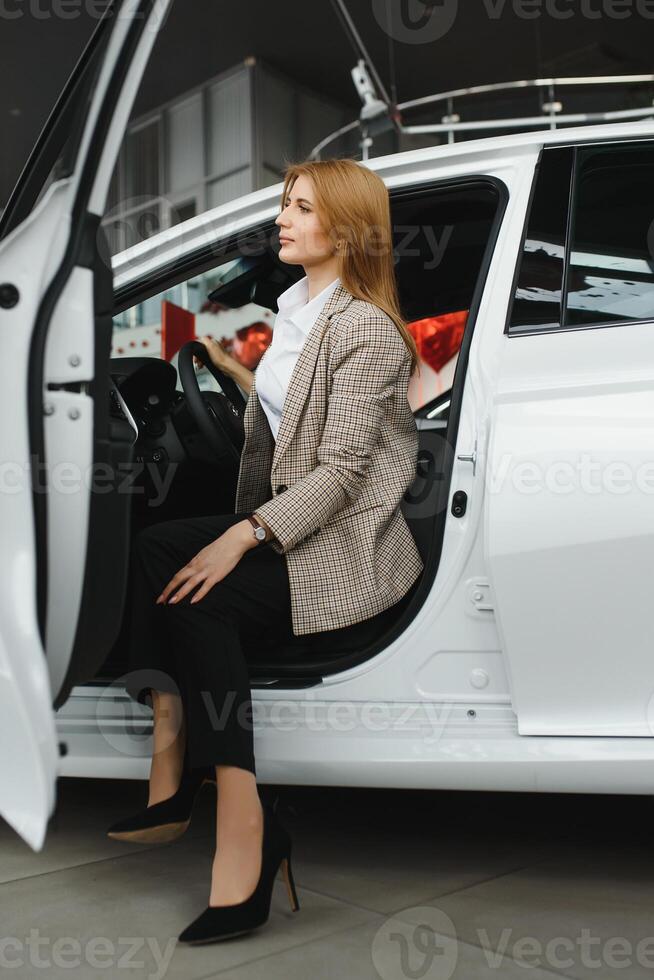 Foto von glücklich jung Frau Sitzung Innerhalb ihr Neu Wagen. Konzept zum Auto Vermietung.