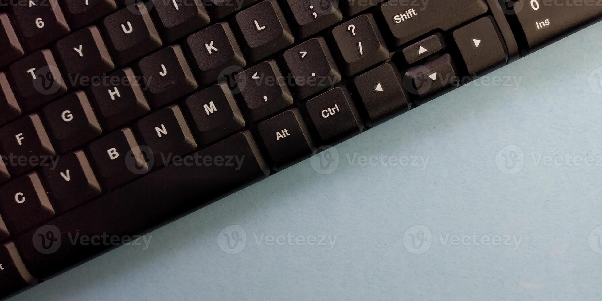 schließen oben von ein schwarz Computer Tastatur auf ein Blau Hintergrund mit Kopieren Raum foto