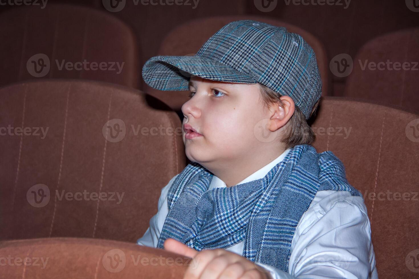 ein süß Teenager Junge im ein Deckel und ein Plaid Schal. das Bild von ein Detektiv. Vergrößerung Glas im Hand. foto