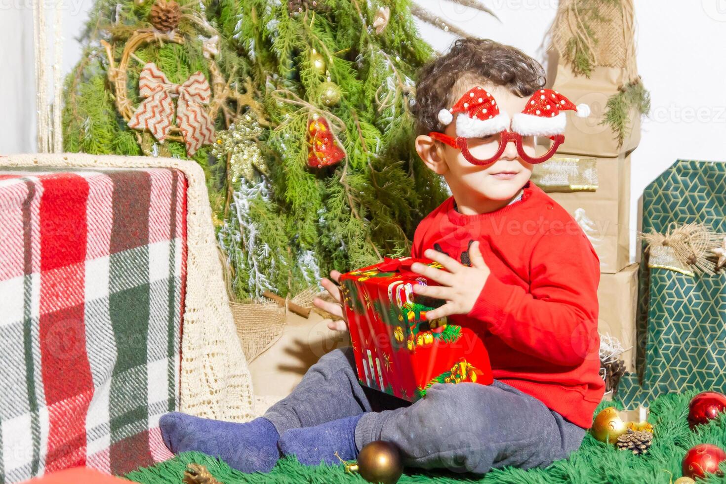 das wenig Kind spielen mit Weihnachten Dekorationen im Studio, wenig Kind mit Weihnachten Ball foto