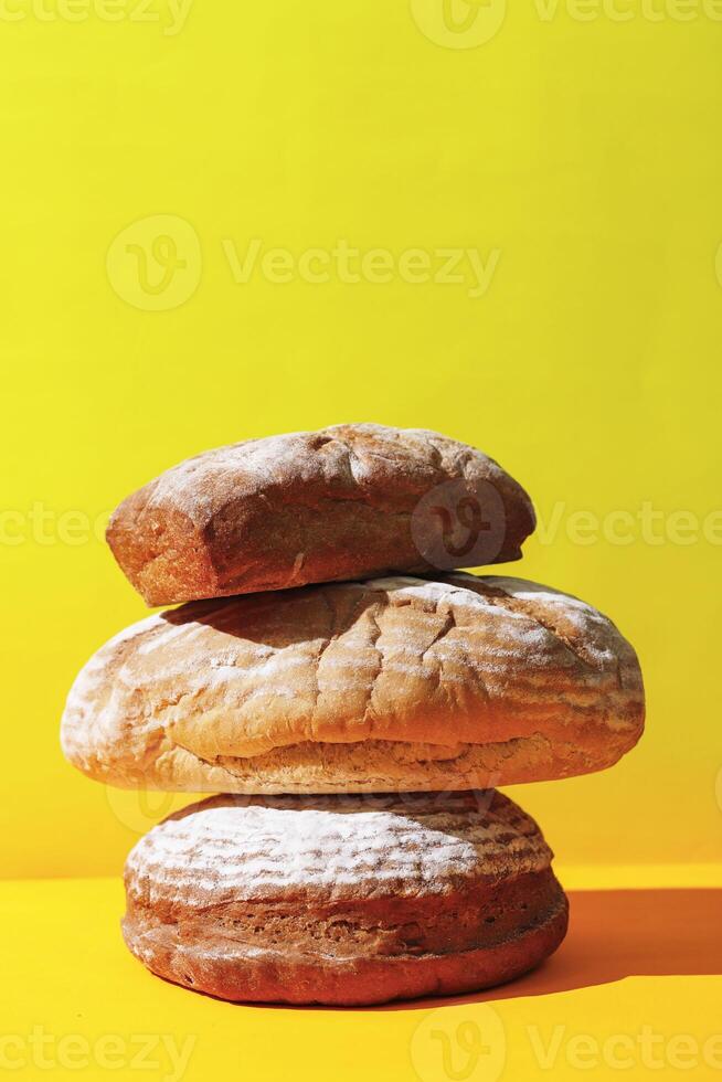 gestapelt Sauerteig Brot auf Gelb Oberfläche foto
