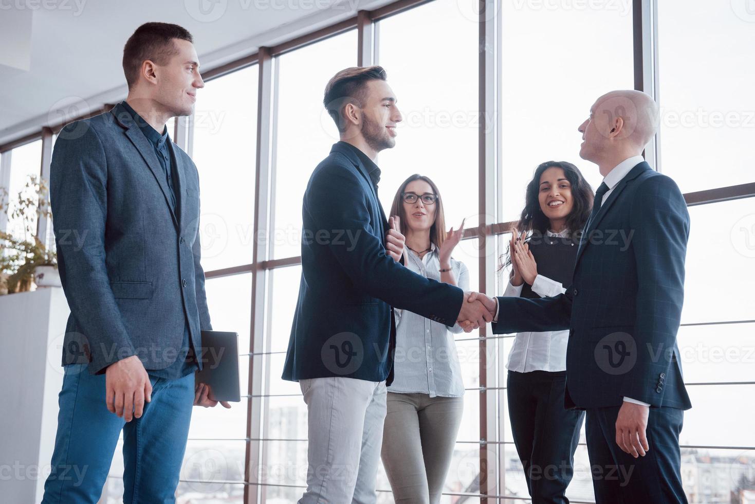 zwei selbstbewusste geschäftsleute, die sich während eines treffens im büro die hände schütteln, gruß- und partnerkonzept foto