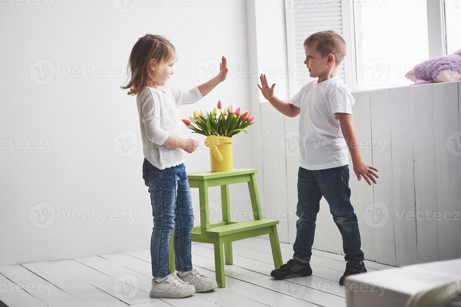 schöner Junge und Mädchen mit Tulpen. Muttertag, 8. März, alles Gute zum Geburtstag foto