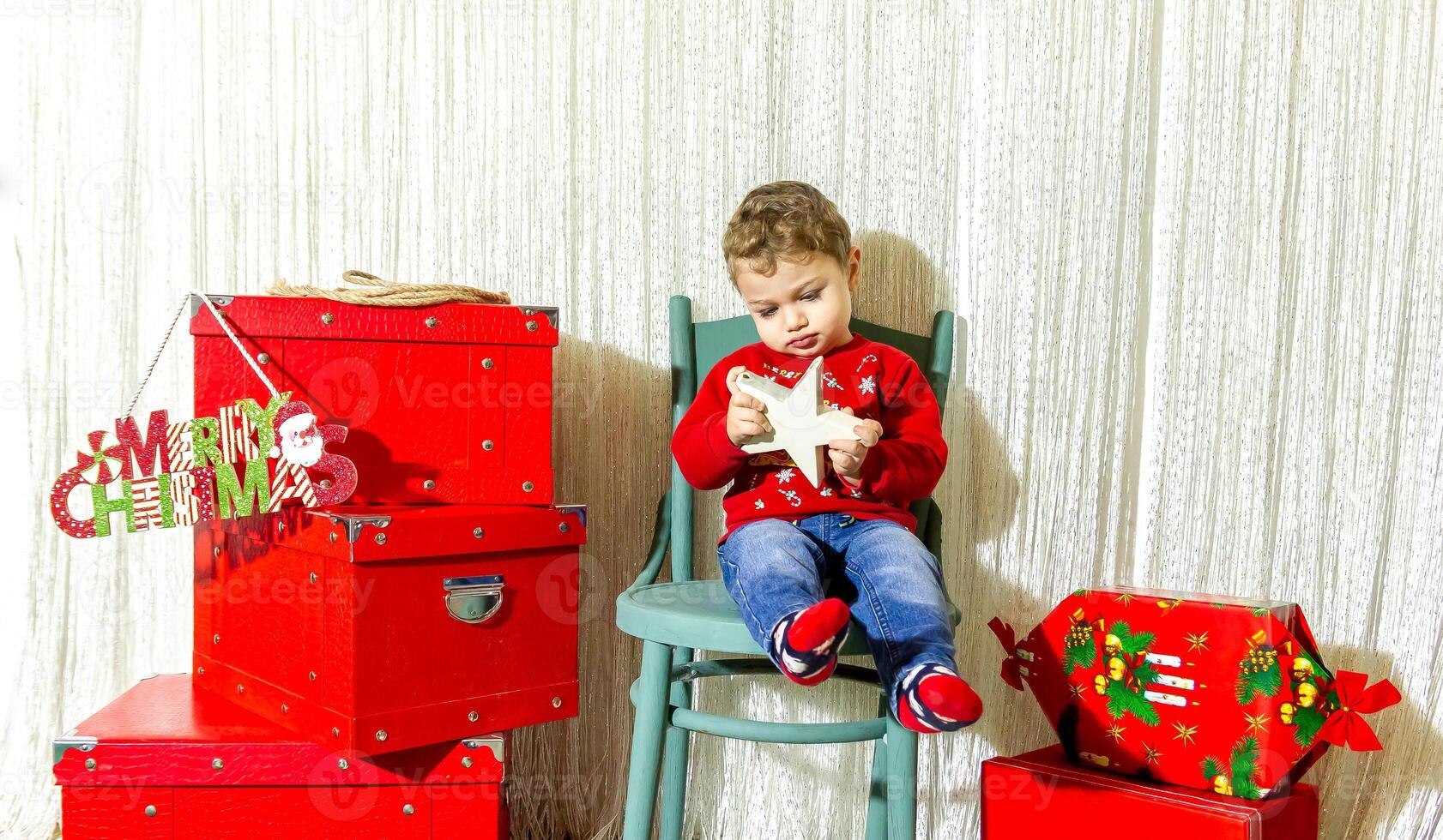 das wenig Kind spielen mit Weihnachten Dekorationen im Studio, wenig Kind mit Weihnachten Ball foto