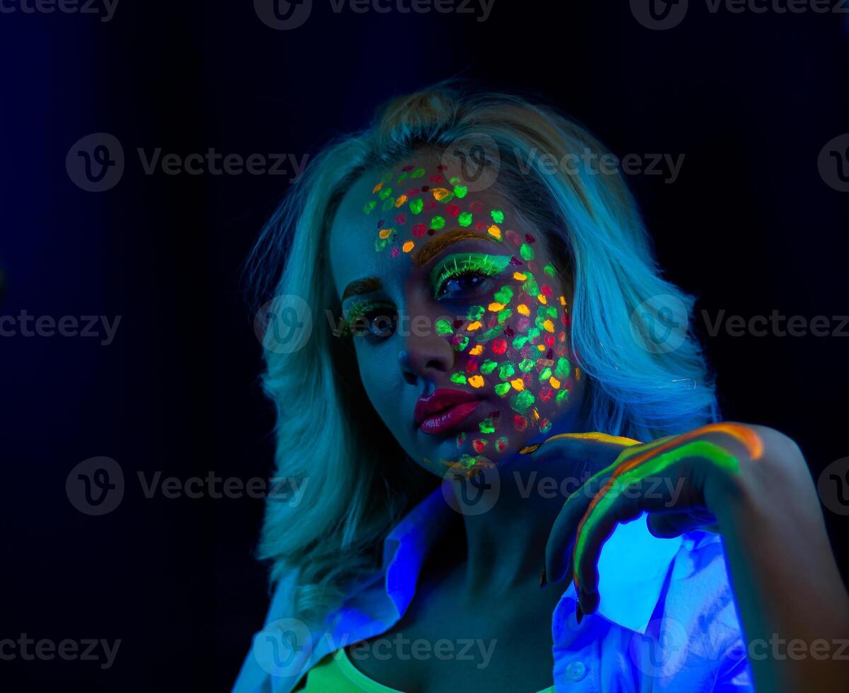 Porträt von ein Frau mit gemalt Gesicht, Frau mit uv bilden im Studio, Porträt von ein Frau im Karneval Maske, das Frau ist dekoriert im ein ultraviolett Pulver foto