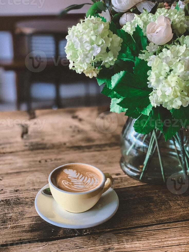 Kaffee Tasse und Blume Vase auf hölzern Tisch, Lager Foto