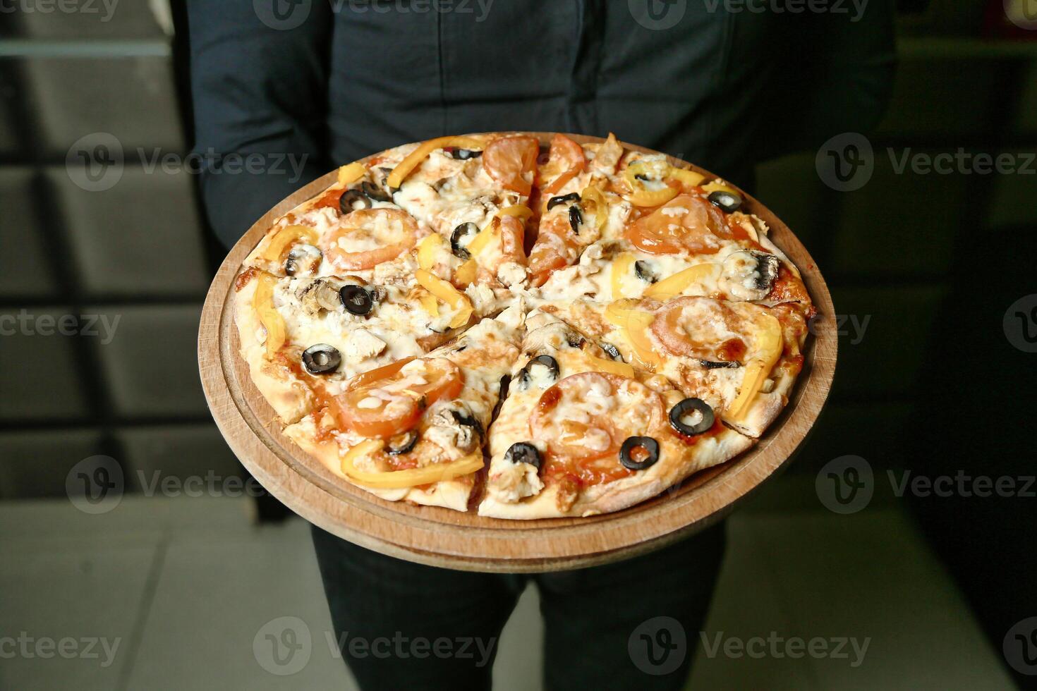 Person halten ein Pizza mit Oliven foto