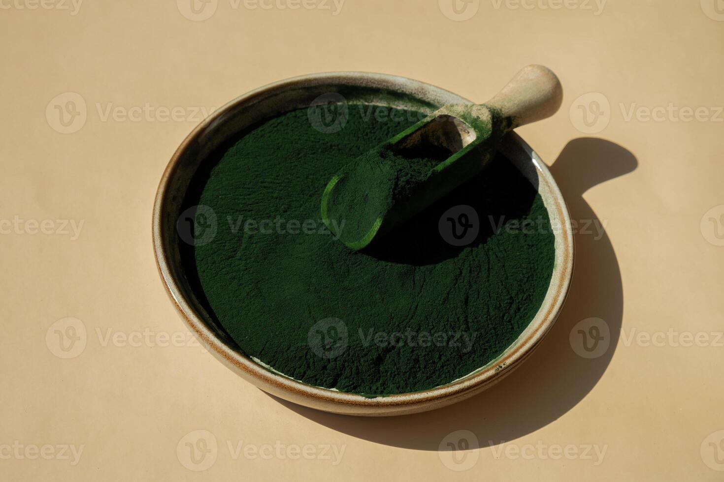 natürlich organisch Grün Spirulina Algen Pulver im Schüssel und hölzern Löffel auf neutral Hintergrund. Chlorella Seetang vegan Superfood Ergänzung Quelle und Entgiftung. Kopieren Raum gesund ernährungsphysiologisch Antioxidans Konzept foto