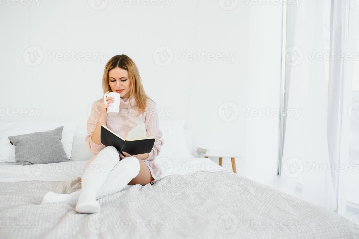 schön Frau lesen Buch im das Bett. entspannend Konzept foto