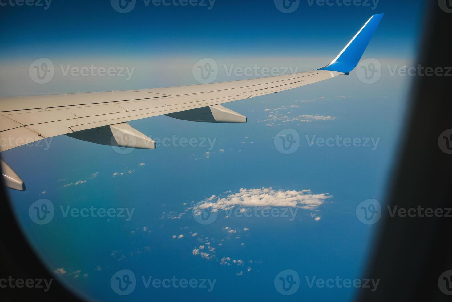 Wolken und Himmel durch das Fenster eines Flugzeugs gesehen foto