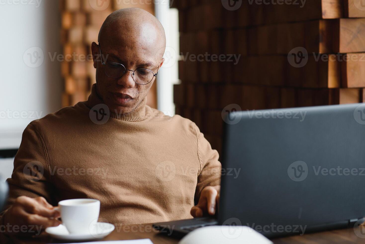 schließen oben Porträt von jung Mann Sitzung im Cafe Arbeiten auf Laptop Computer. foto
