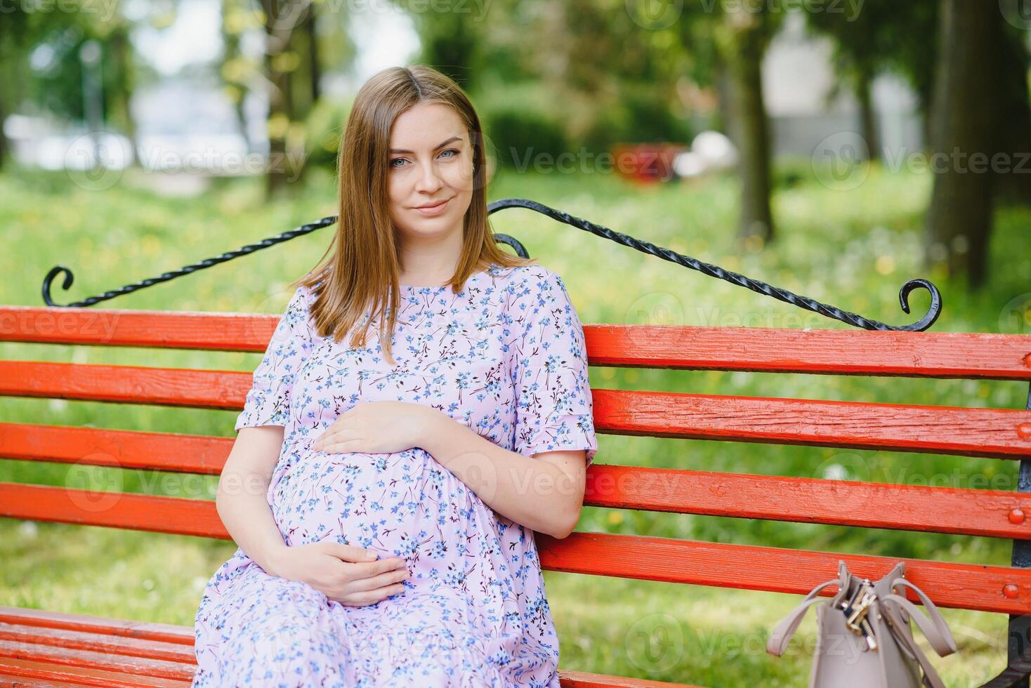 schöne schwangere Frau, die sich im Park entspannt foto