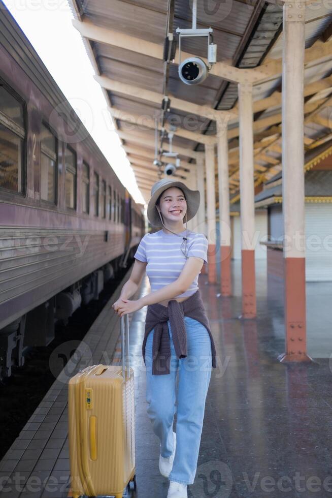 jung Frau mit Koffer wartet beim das Metro Bahnhof während das Zug kommt an, Tourismus und Reise im das Sommer. Urlaube zum das Student. Arbeit und Reise foto