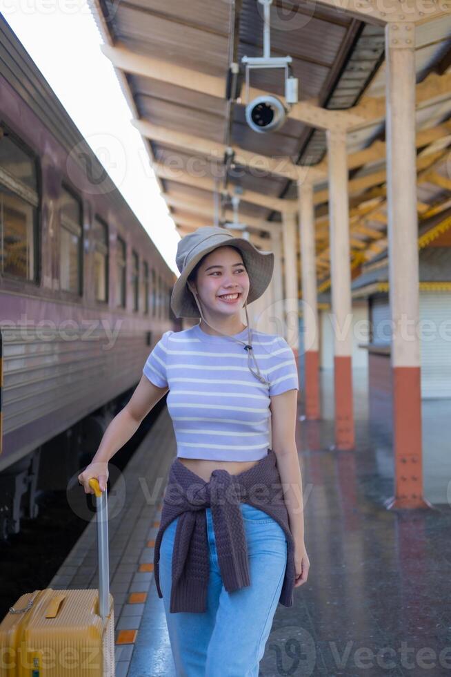 jung Frau mit Koffer wartet beim das Metro Bahnhof während das Zug kommt an, Tourismus und Reise im das Sommer. Urlaube zum das Student. Arbeit und Reise foto