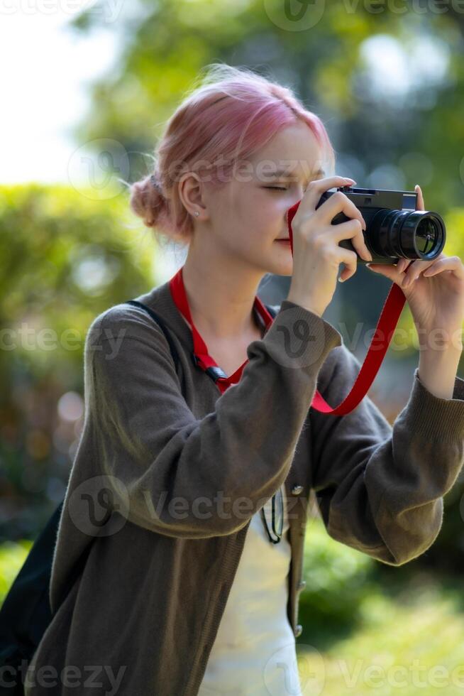 schön jung Künstler Frau nehmen Foto im Blumen Garten. jung süß Mädchen tragen das Kamera im das Garten