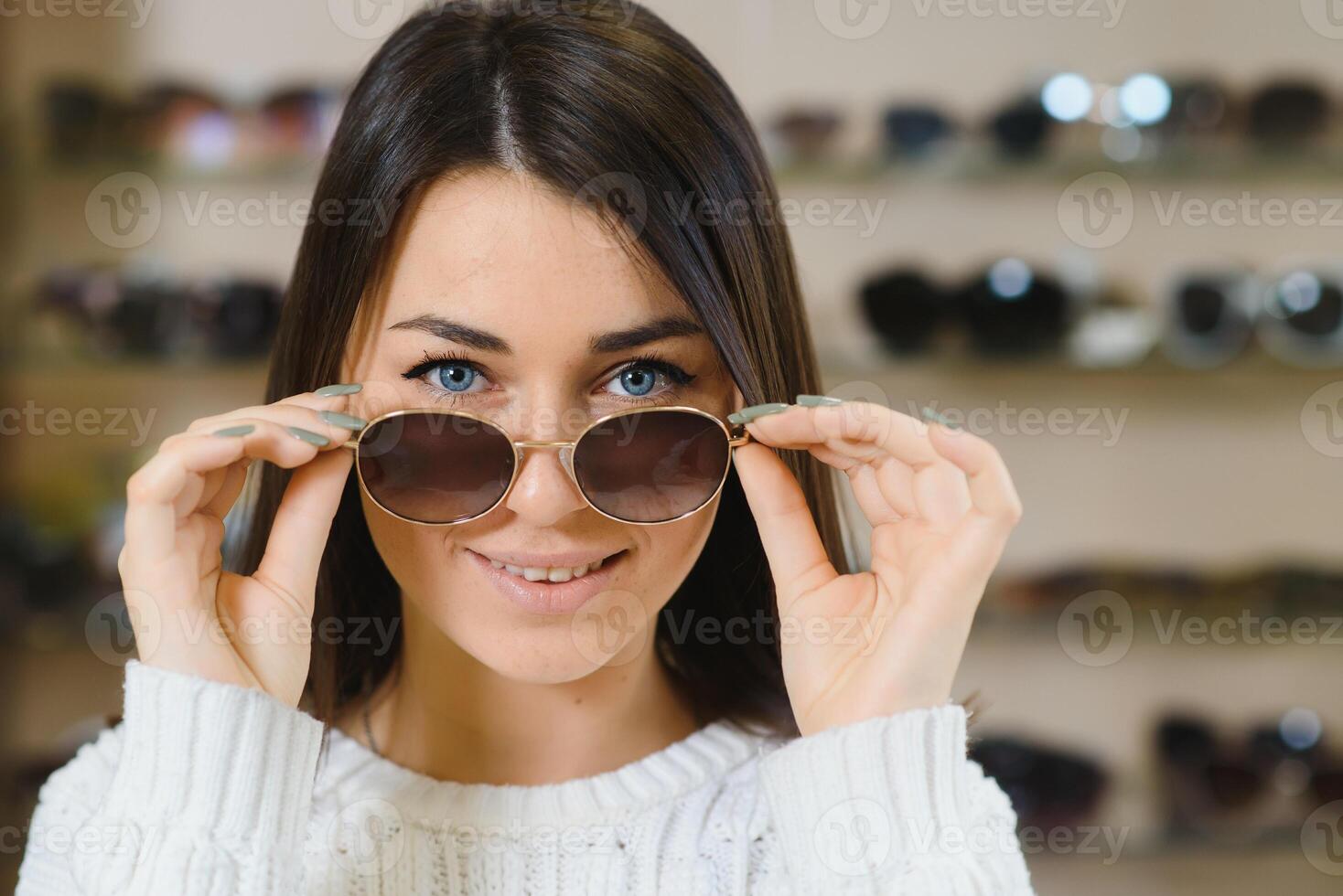 welche einer ist besser passen Mich. Porträt von heiter zögernd Frau im Optiker speichern, Herstellung Entscheidung, halten stilvoll Sonnenbrille, wählen Was sie sollte besorgen. großartig Rabatte zum Kauf zwei Paare. foto