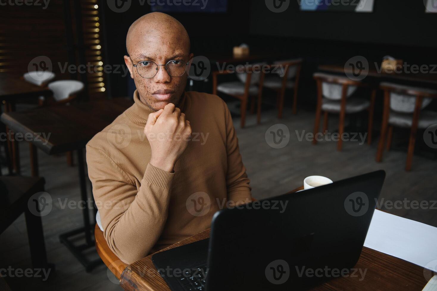 afrikanisch amerikanisch Geschäft Mann mit Laptop im ein Cafe. foto