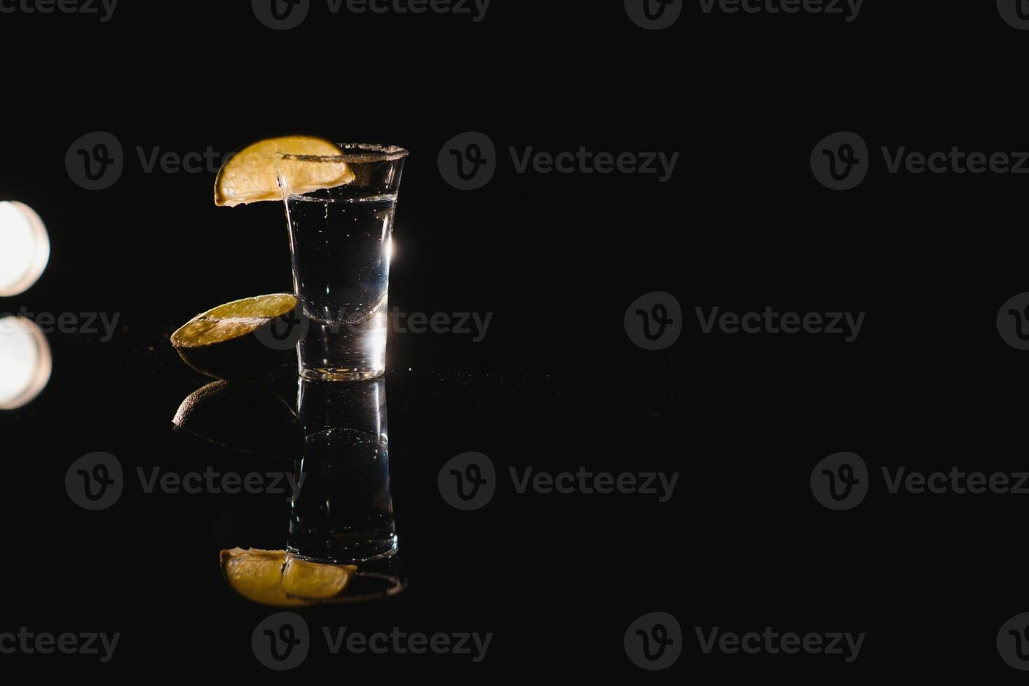 lecker Alkohol trinken Cocktail Tequila mit Limette und Salz- auf beschwingt dunkel Hintergrund. Nahaufnahme. foto