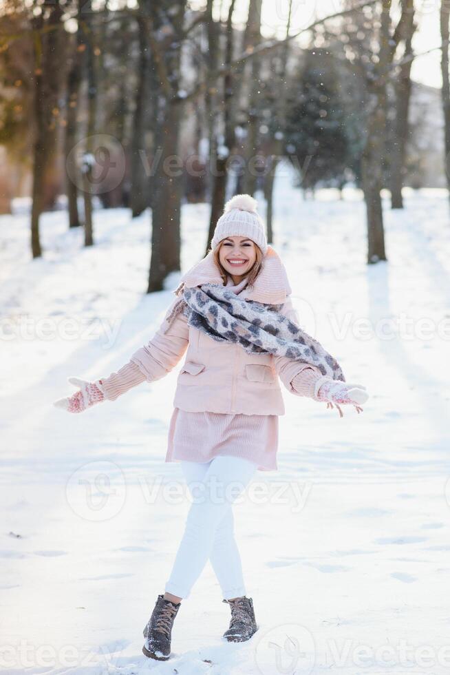 schönes Winterporträt der jungen Frau in der schneebedeckten Winterlandschaft foto