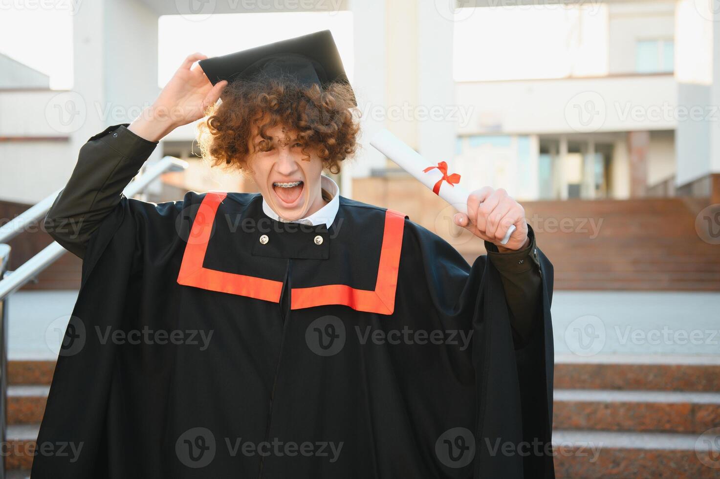 aufgeregt Absolvent Schüler im Kleid mit auferstanden Hände halten Diplom. foto