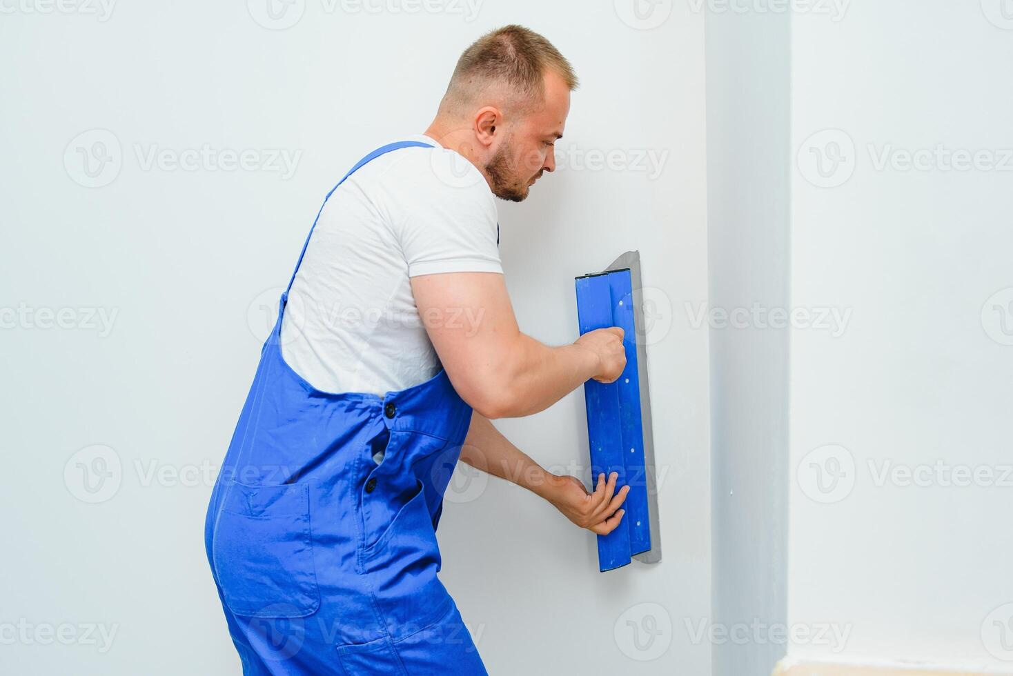 ein Mann Prozesse das Mauer mit ein Spatel. Stuckateur beim arbeiten. foto