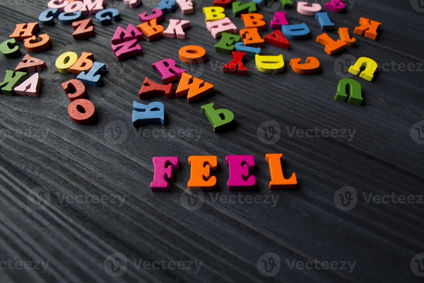 Mehrfarbig Briefe auf ein dunkel Blau hölzern Hintergrund. bunt hölzern Alphabet auf ein Tisch. foto