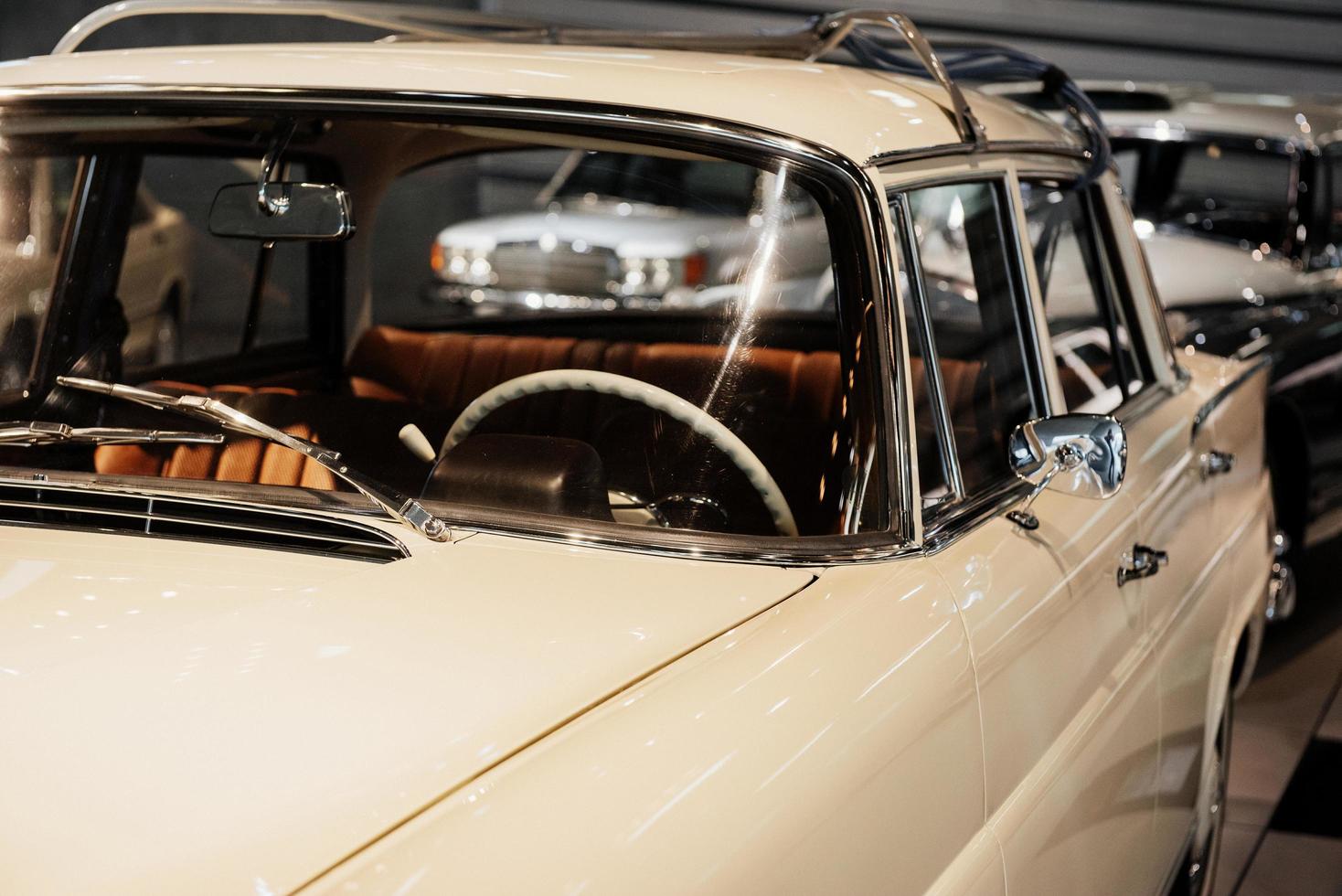 genau hinsehen. beschnittenes Bild eines weißen Oldtimers, der auf der Automobilausstellung drinnen geparkt wurde foto