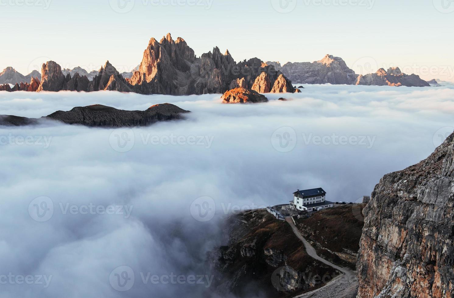 Zivilisation direkt auf dem Weg. Morgensonne wird den Nebel an diesem wunderschönen Bergort zerstreuen foto