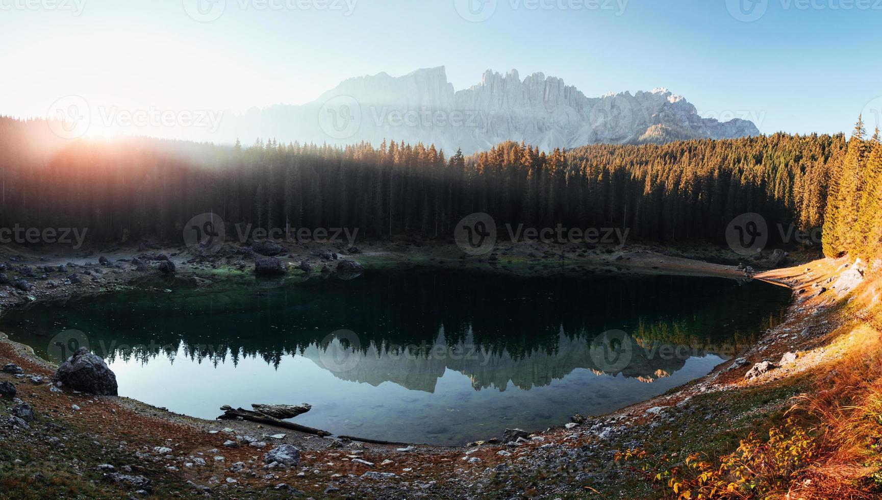 Ein neuer Tag hat begonnen. Herbstlandschaft mit klarem See, Tannenwald und majestätischen Bergen. Panoramafoto foto