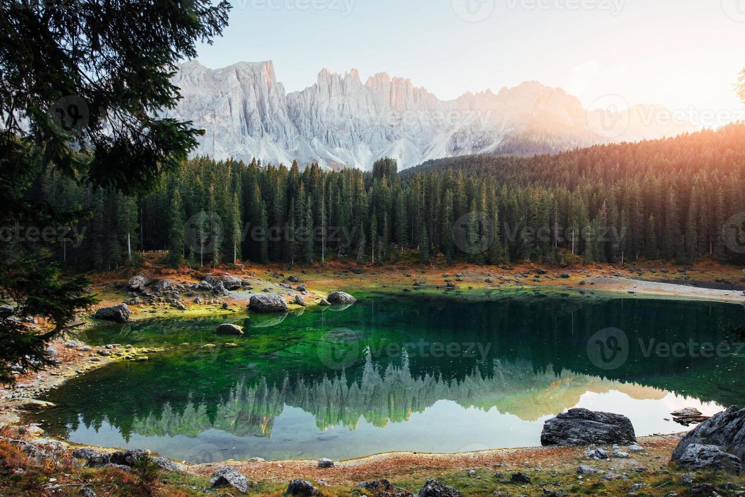 grüne Tanne auf der linken Seite. Herbstlandschaft mit klarem See, Tannenwald und majestätischen Bergen foto