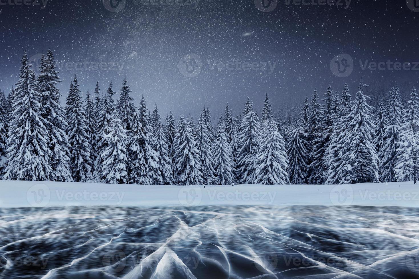 Molkerei Star Trek über den Winterwäldern. Risse auf der Oberfläche des blauen Eises in der Nähe von Kiefernhügeln. zugefrorener See in den Bergen. karpaten ukraine europa foto