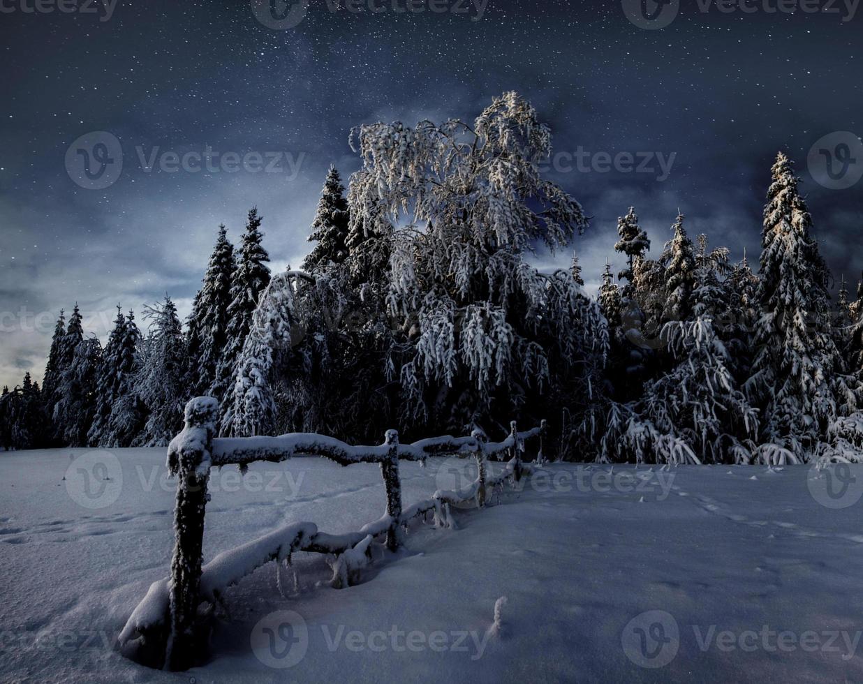 Winterlandschaft. Bergdorf in den ukrainischen Karpaten. lebendiger Nachthimmel mit Sternen und Nebel und Galaxie. Deep-Sky-Astrofoto foto