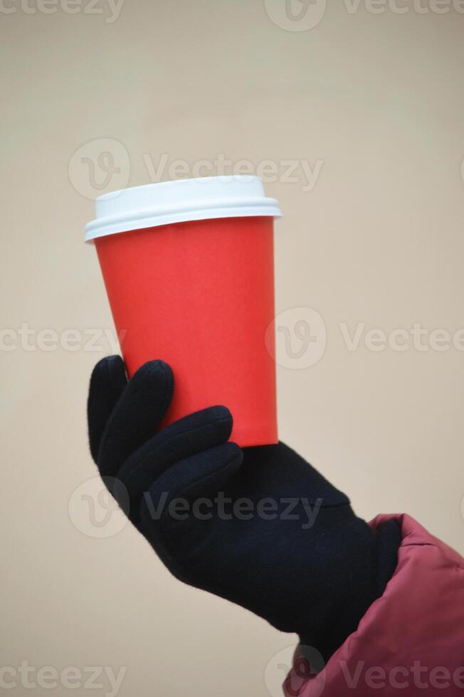 ein Frau Hand hält ein Papier rot Einweg Tasse zum Kaffee. Attrappe, Lehrmodell, Simulation. Platz zum Logo. foto